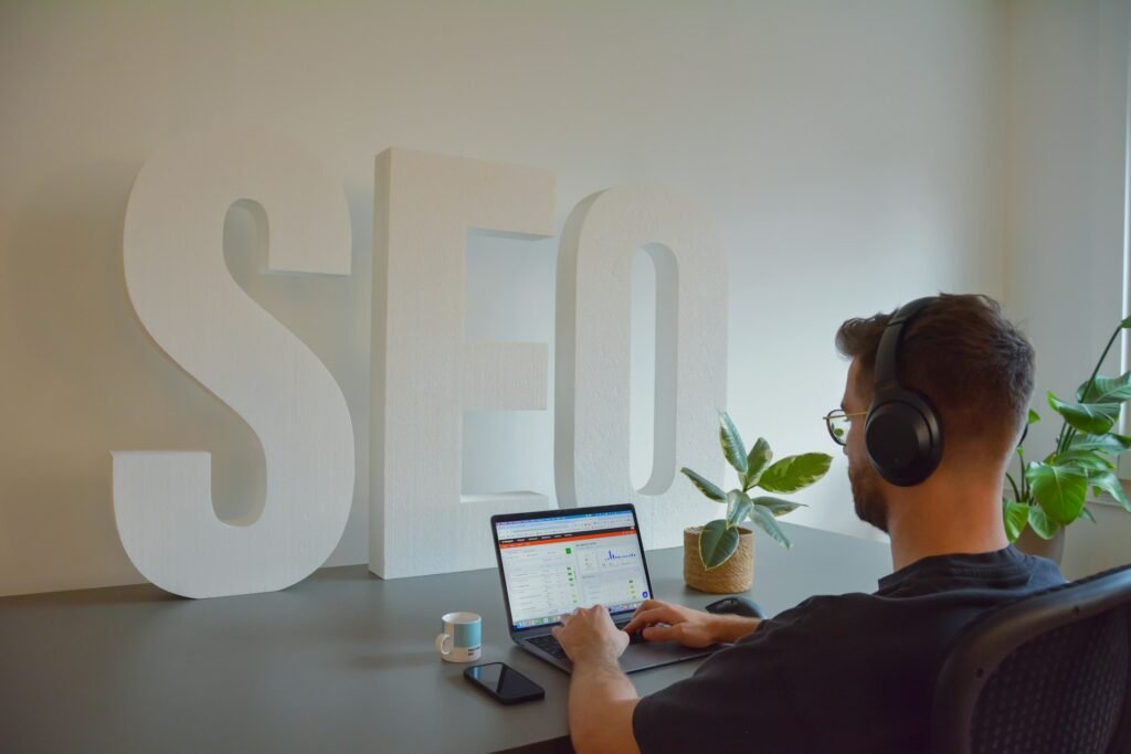 Profesional trabajando en un ordenador frente a unas letras de SEO