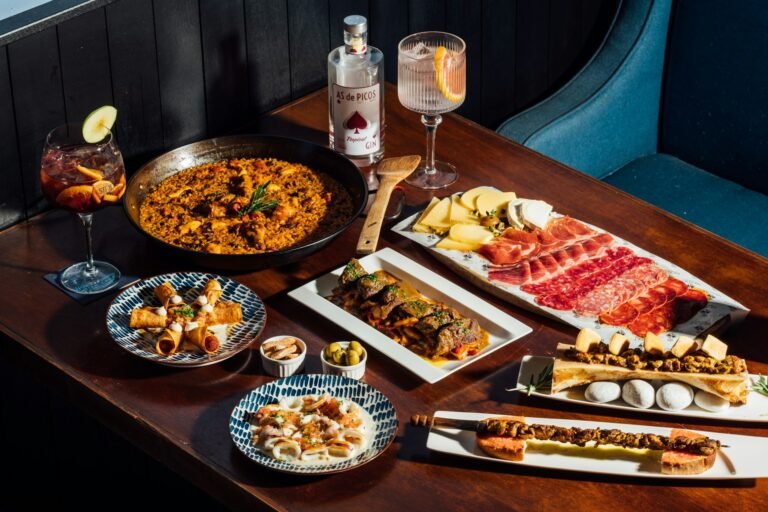 Mesa de restaurante con platos para compartir y bebidas